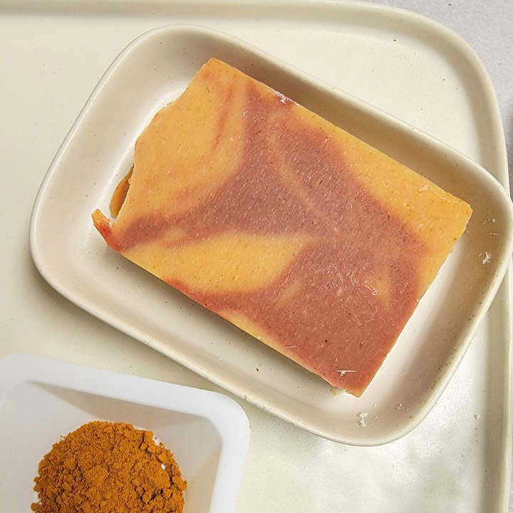 Infused with turmeric powder and Himalayan rhubarb root, this soap helps improve the appearance of uneven skin tones and provides a natural radiance. Kaolin clay and Brazilian red clay gently detoxify, purify, and brighten the complexion without drying, while the essential oil blend of turmeric, ho wood, ylang ylang, anise star, and lemongrass delivers antimicrobial benefits, balances the skin, and promotes relaxation.